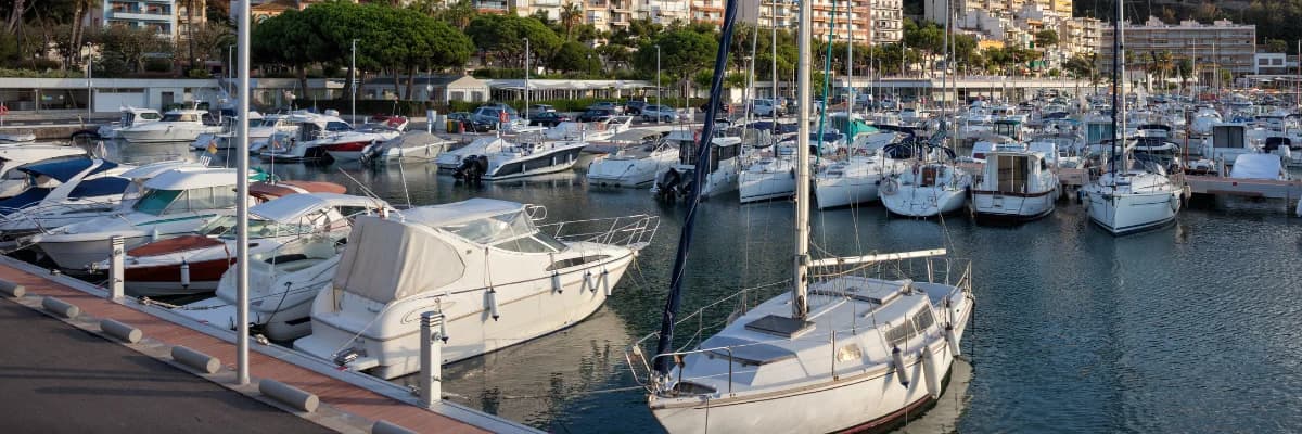 Sailboats and powerboats berthed along the docks of a busy marina